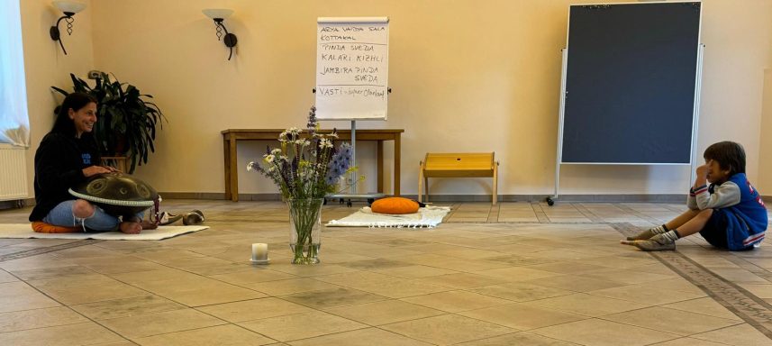 Zwei Personen in einem Raum, eine sitzt auf dem Boden und die andere sitzt gegenüber.
