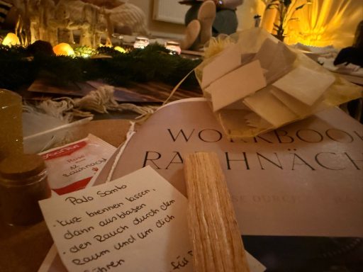 Dekorative Objekte und Notizen auf einem Tisch, umgeben von festlicher Beleuchtung.