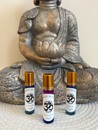 Buddhistische Statue mit drei Aromafläschchen in goldenen Rollen.