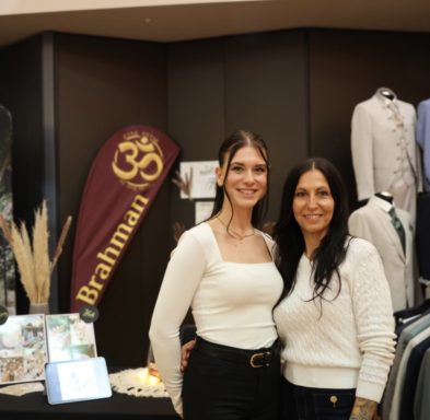 Zwei Frauen stehen vor Kleidungsgestellen in einem Modegeschäft.